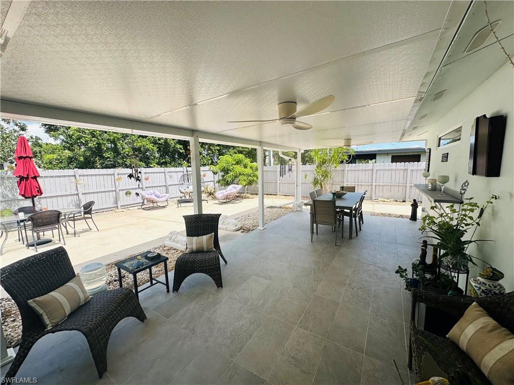 Expansive covered patio featuring a full ceiling, dual ceiling fans, and tiled flooring