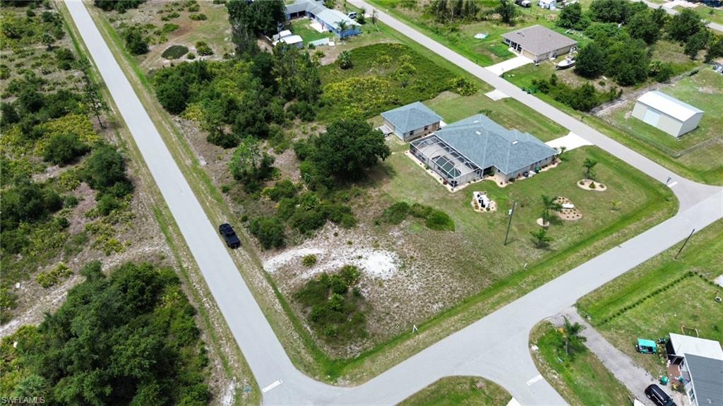 Expansive corner lot featuring a single-story residence with an attached garage and a detached accessory structure