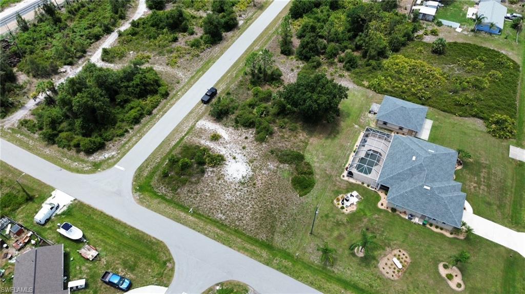Aerial perspective showcasing a corner lot with undeveloped land