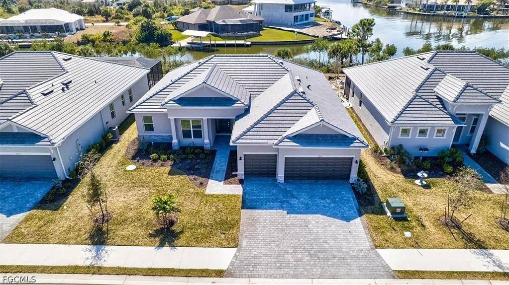 Contemporary residence featuring a paver driveway, two-car garage, and a covered entry
