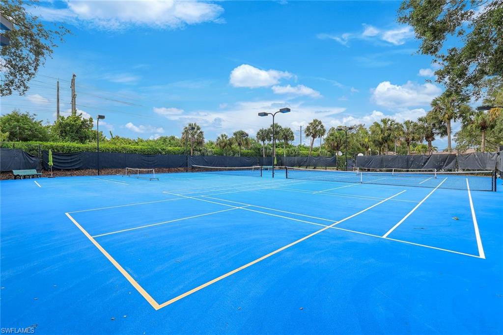 Full-size tennis court with a blue playing surface and white boundary lines