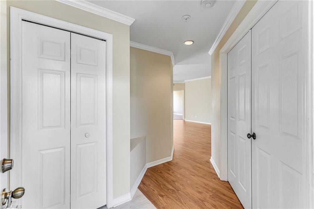 Entryway featuring wood-finish flooring, recessed lighting, crown molding, and two panel bi-fold doors