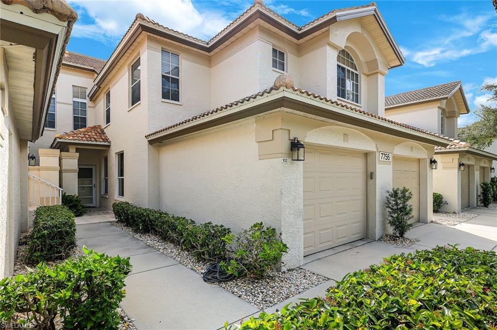 Stucco exterior with tile roofing and arched window details