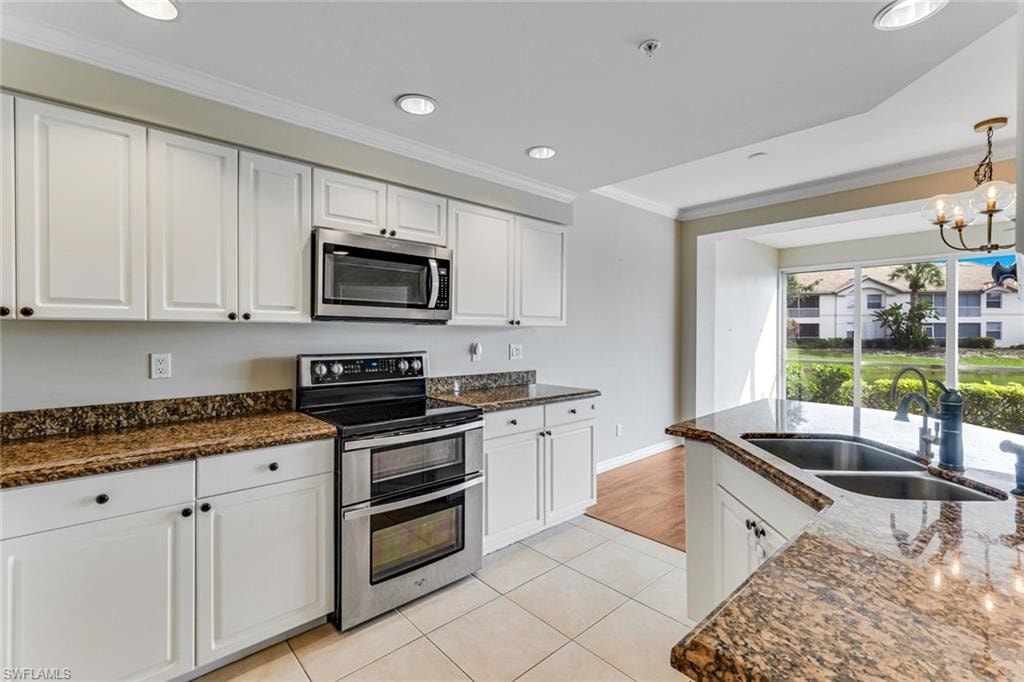 Contemporary kitchen featuring white cabinetry with dark hardware and speckled countertops