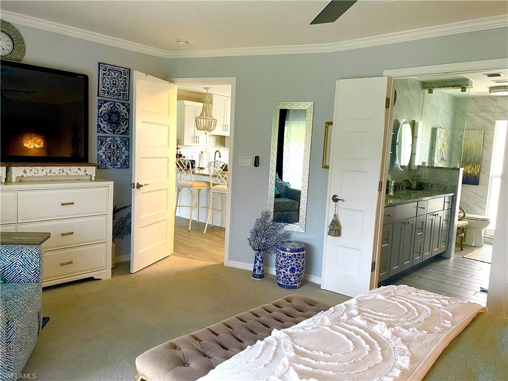 Double sink vanity in ensuite bathroom with large TV and dresser