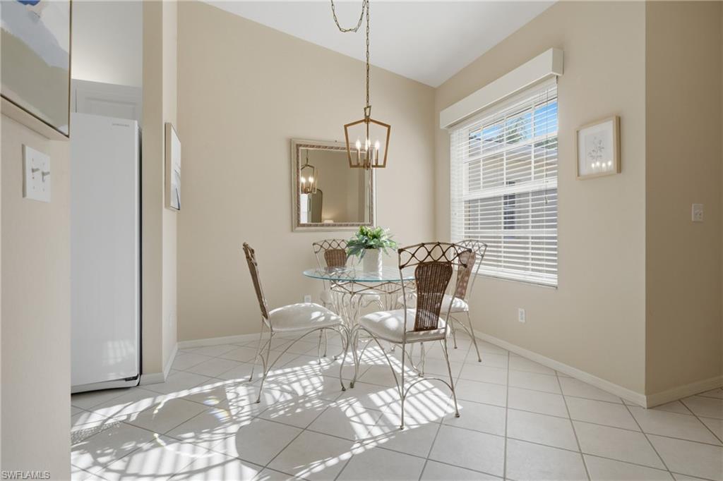 Dining area featuring a window with blinds, a hanging pendant light fixture, tiled flooring, and neutral wall tones