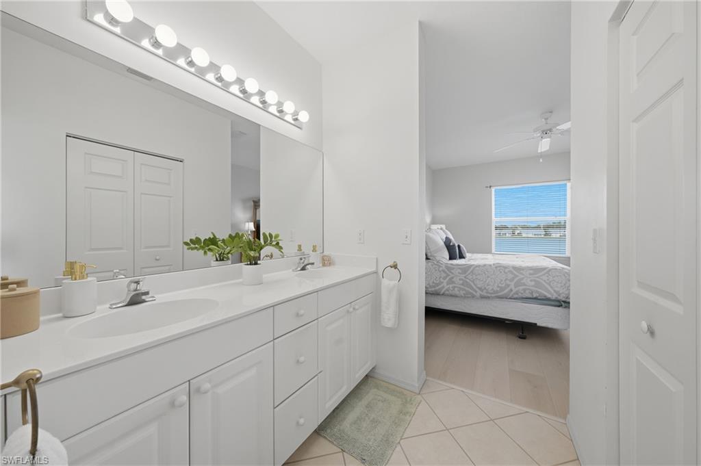 Bathroom featuring a dual vanity with white cabinetry and a full-width mirror