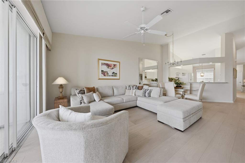 Spacious living area featuring light wood-finish flooring and soaring vaulted ceilings