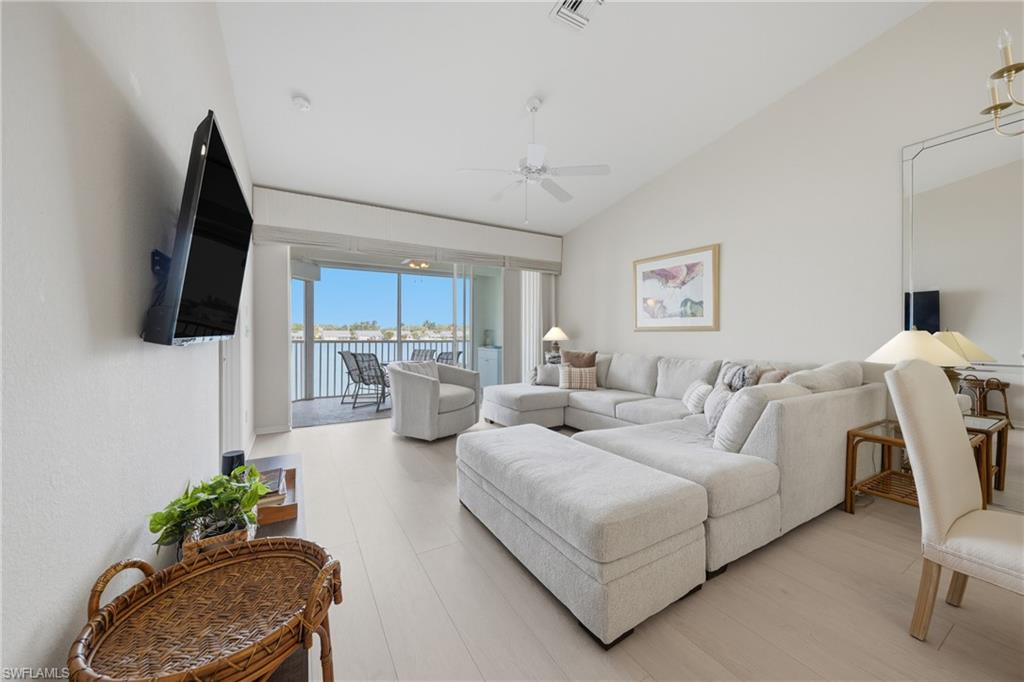 Spacious living area featuring light wood-finish flooring and vaulted ceilings