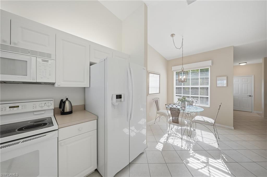 Kitchen featuring white cabinetry, white appliances, and light-toned countertops