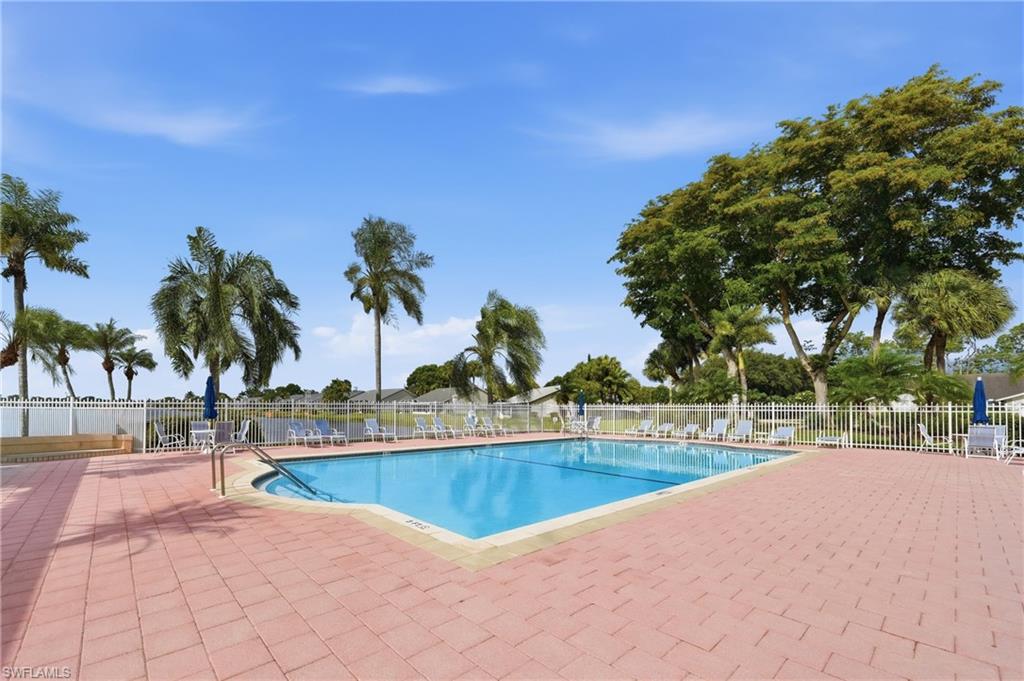 Rectangular swimming pool with integrated steps, surrounded by a red brick paver deck
