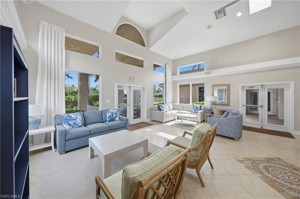 Spacious interior featuring a vaulted ceiling, transom windows, and multiple French doors