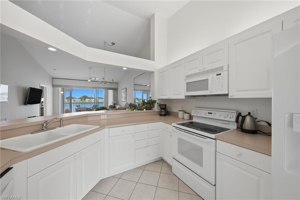 Kitchen with white cabinetry, a double-basin sink, and a built-in microwave