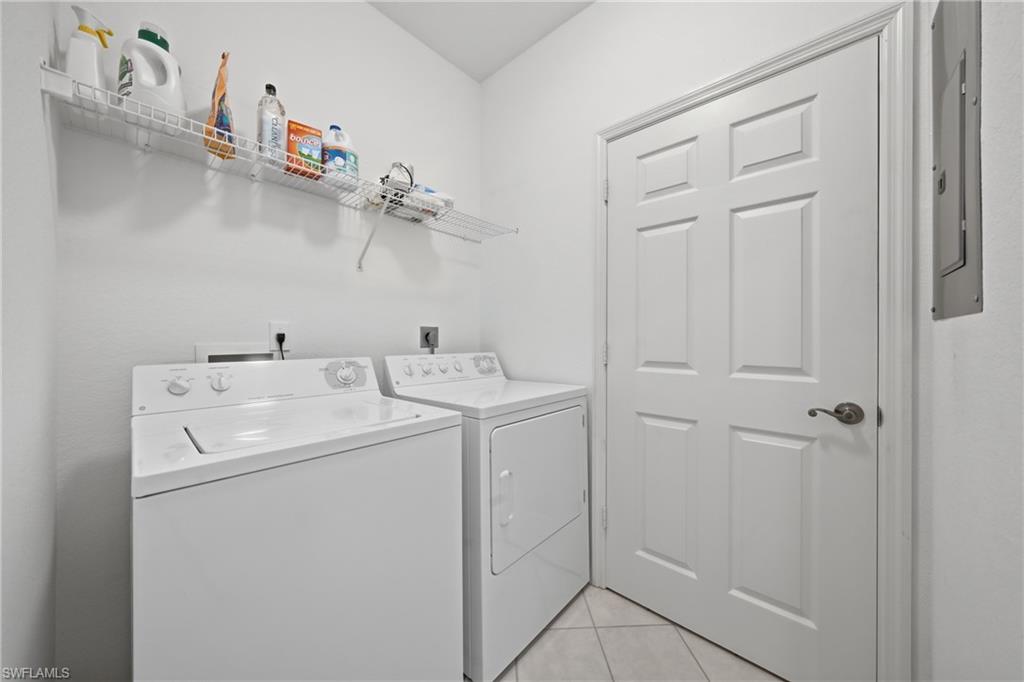 Dedicated laundry area featuring a white wire shelving unit and light-toned tile flooring