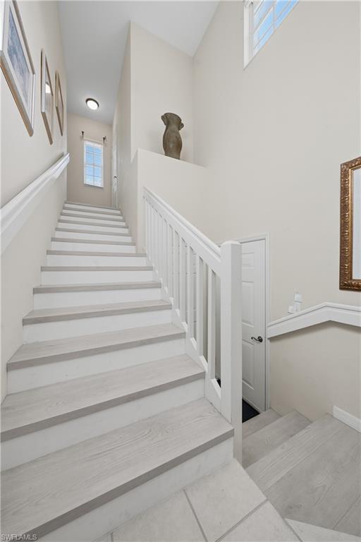Multilevel interior staircase featuring light wood-finish treads and white risers
