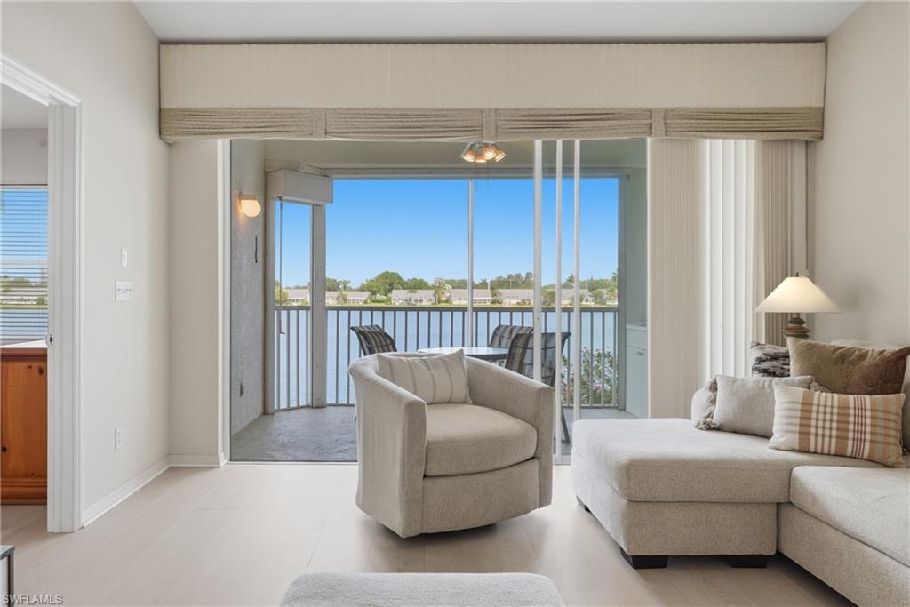Spacious living area featuring light wood-finish flooring and a screened-in patio