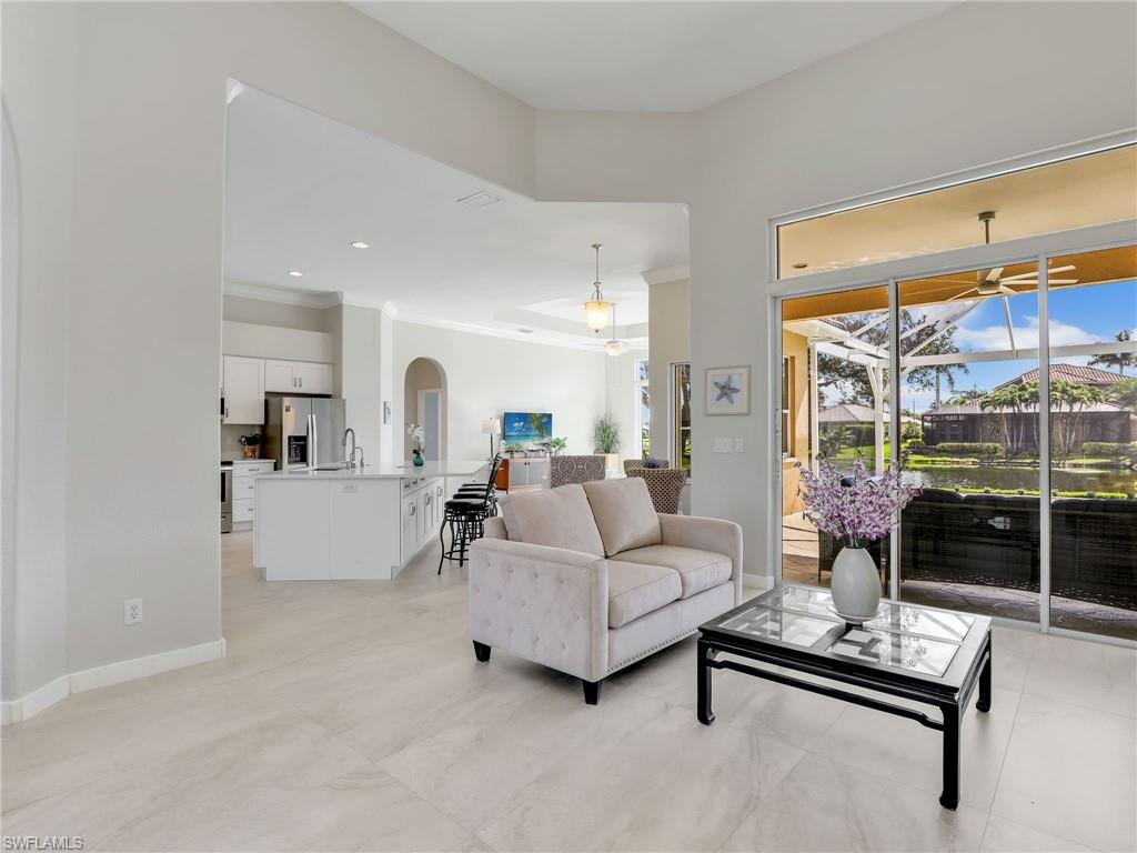 Living area featuring ornamental molding, a ceiling fan, and arched walkways
