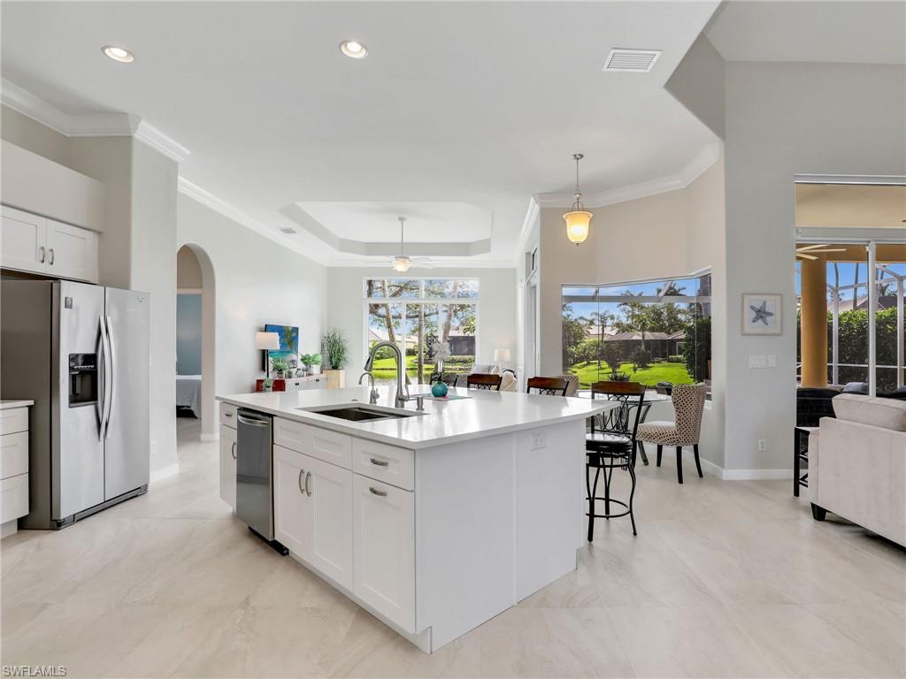 Kitchen featuring appliances with stainless steel finishes, arched walkways, a ceiling fan, white cabinets, and crown molding