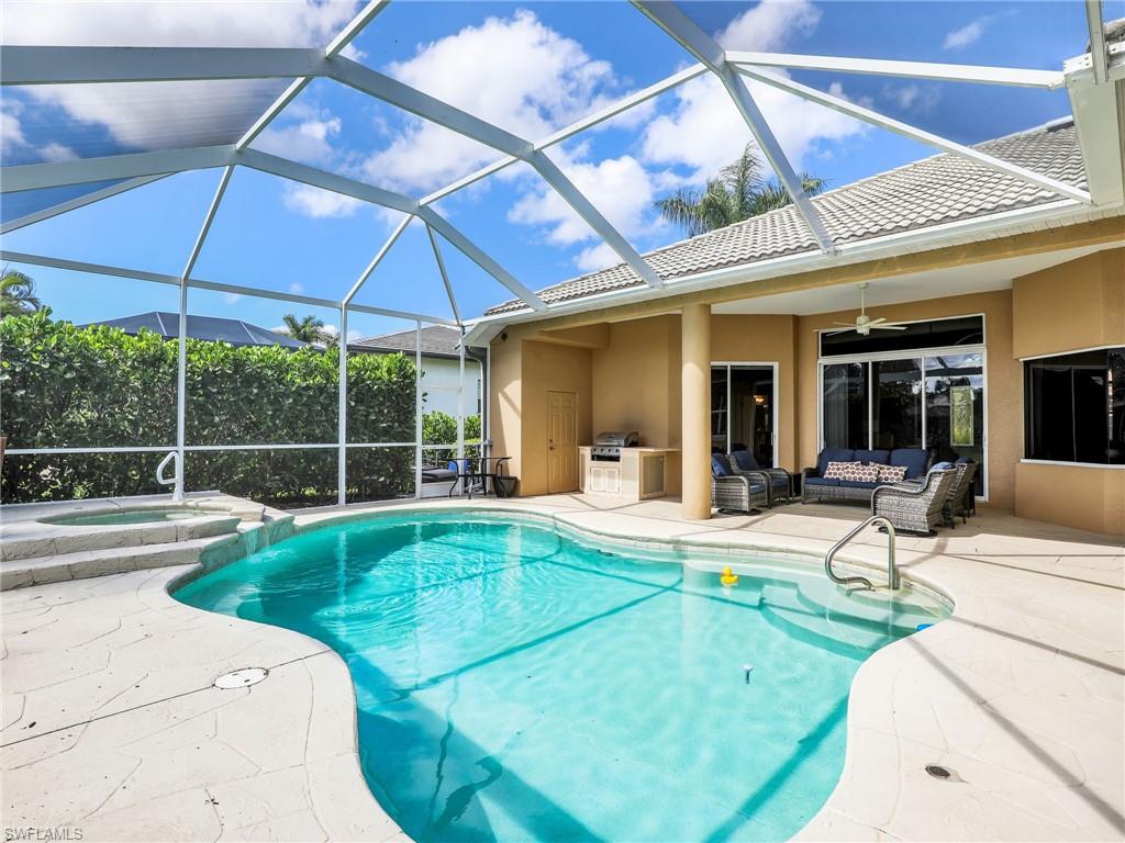 View of swimming pool with an outdoor living space, a patio area, a ceiling fan, an outdoor kitchen, and a pool with connected hot tub