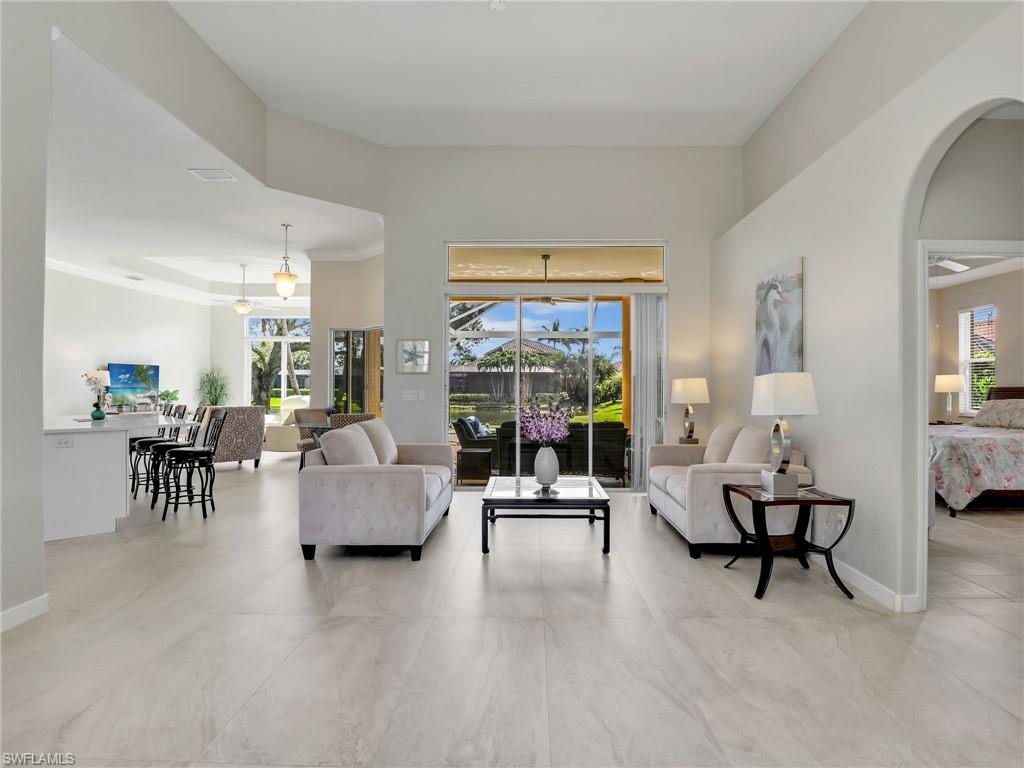 Living area with arched walkways and a towering ceiling