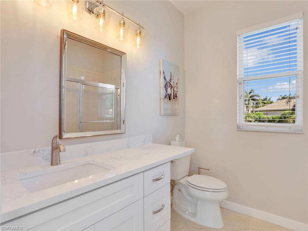 Bathroom with vanity, a shower with shower door, and tile patterned floors