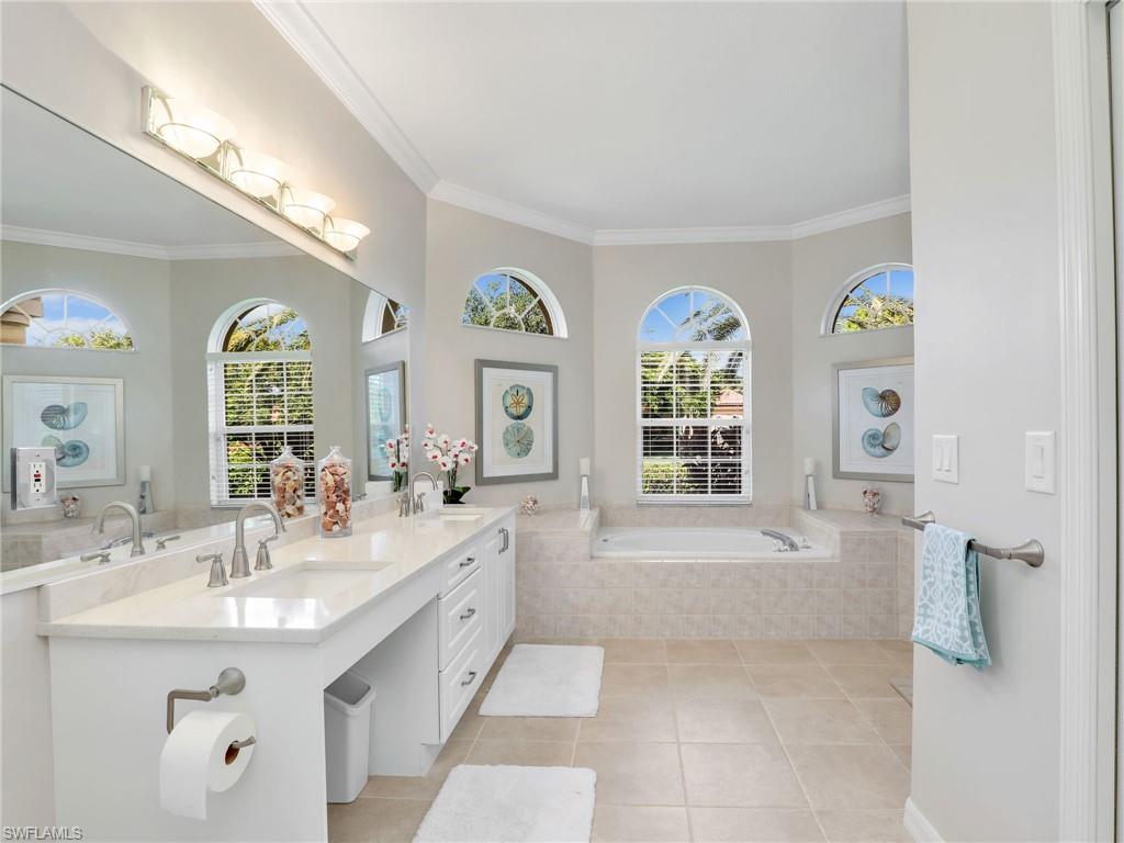 Full bath with a bath, ornamental molding, double vanity, and tile patterned floors