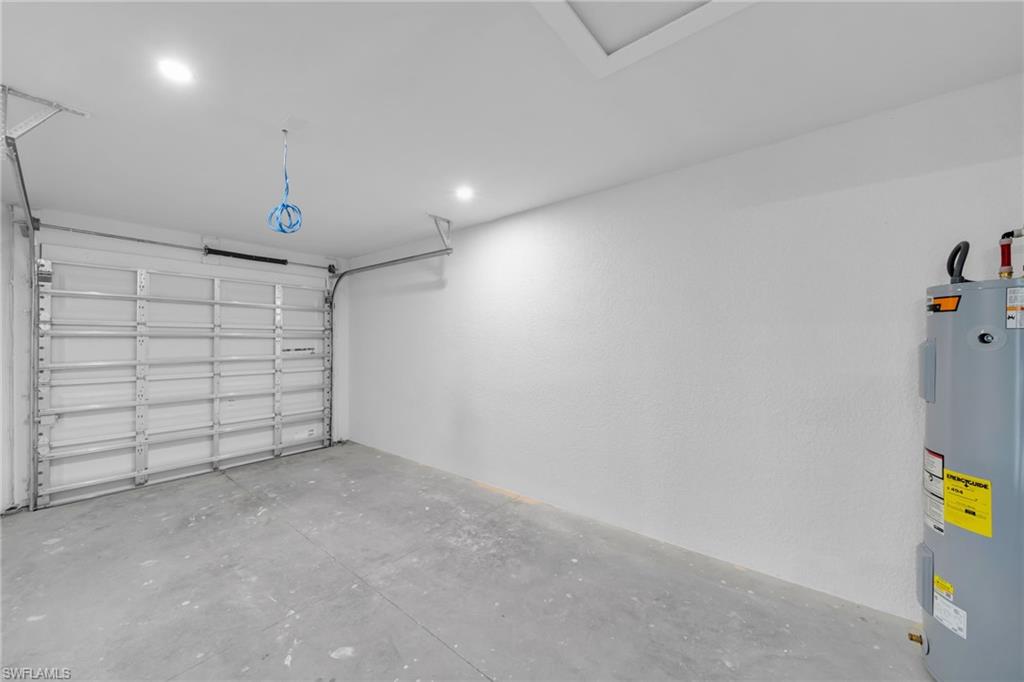 Single-car garage featuring a roll-up door, concrete flooring, and recessed ceiling lighting
