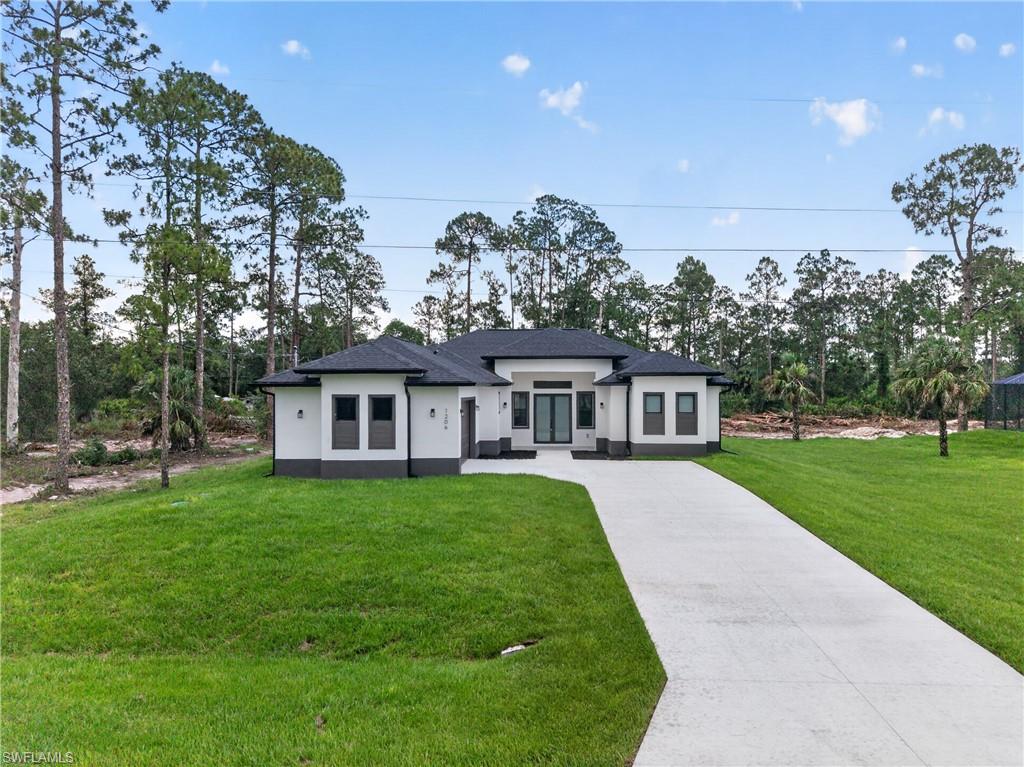 Modern single-story residence featuring a dark shingle roof and a two-tone exterior with white siding and dark gray trim