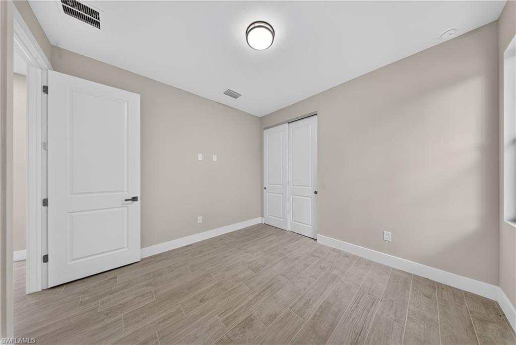 Light-filled interior space with wood-finish tile flooring, neutral wall tones, and white trim