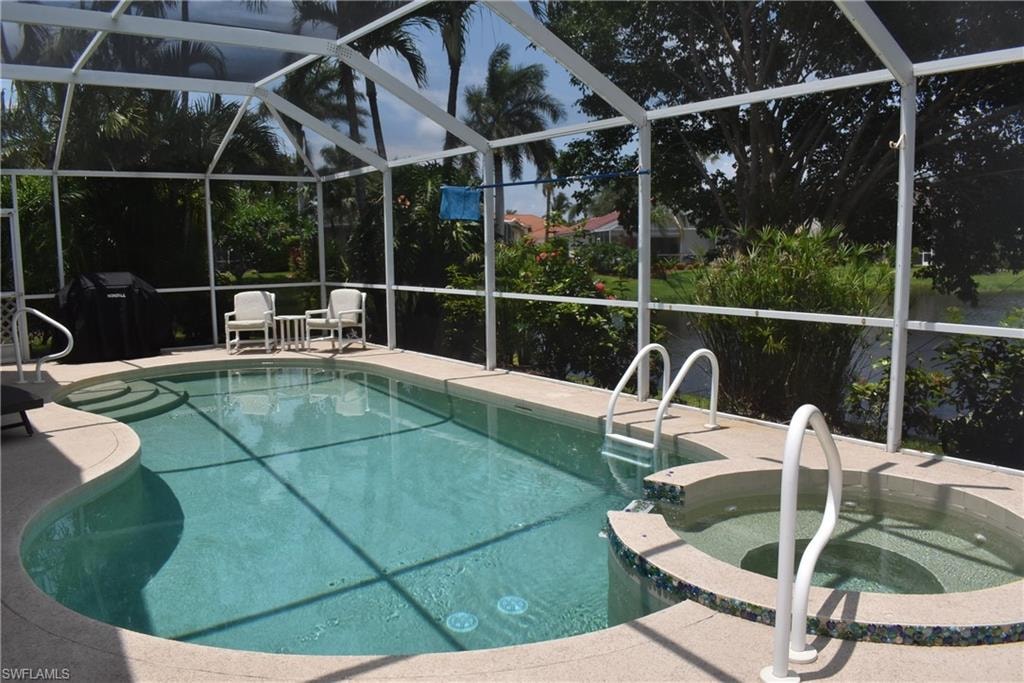 View of swimming pool featuring a lanai, an in ground hot tub, and a patio