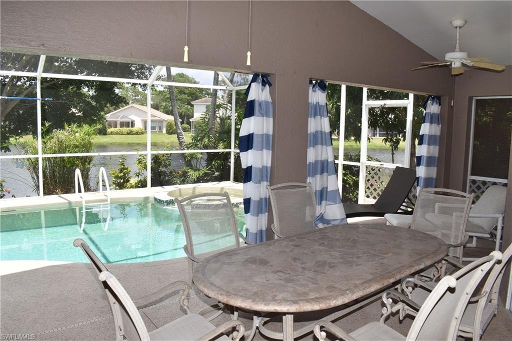 Sunroom with ceiling fan, vaulted ceiling, and a pool