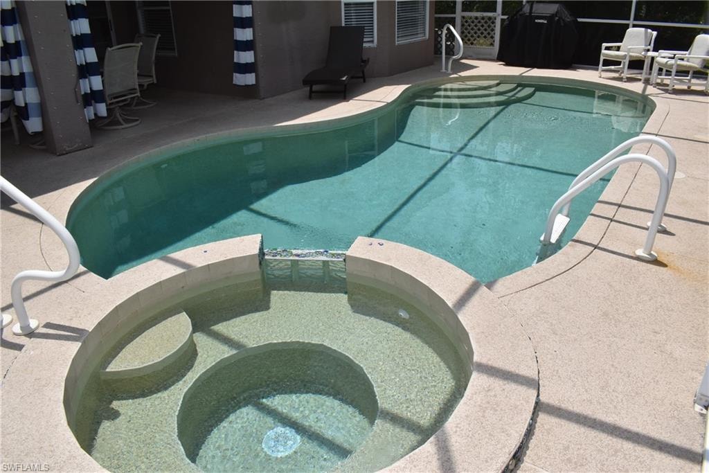 View of swimming pool with a patio area and an in ground hot tub