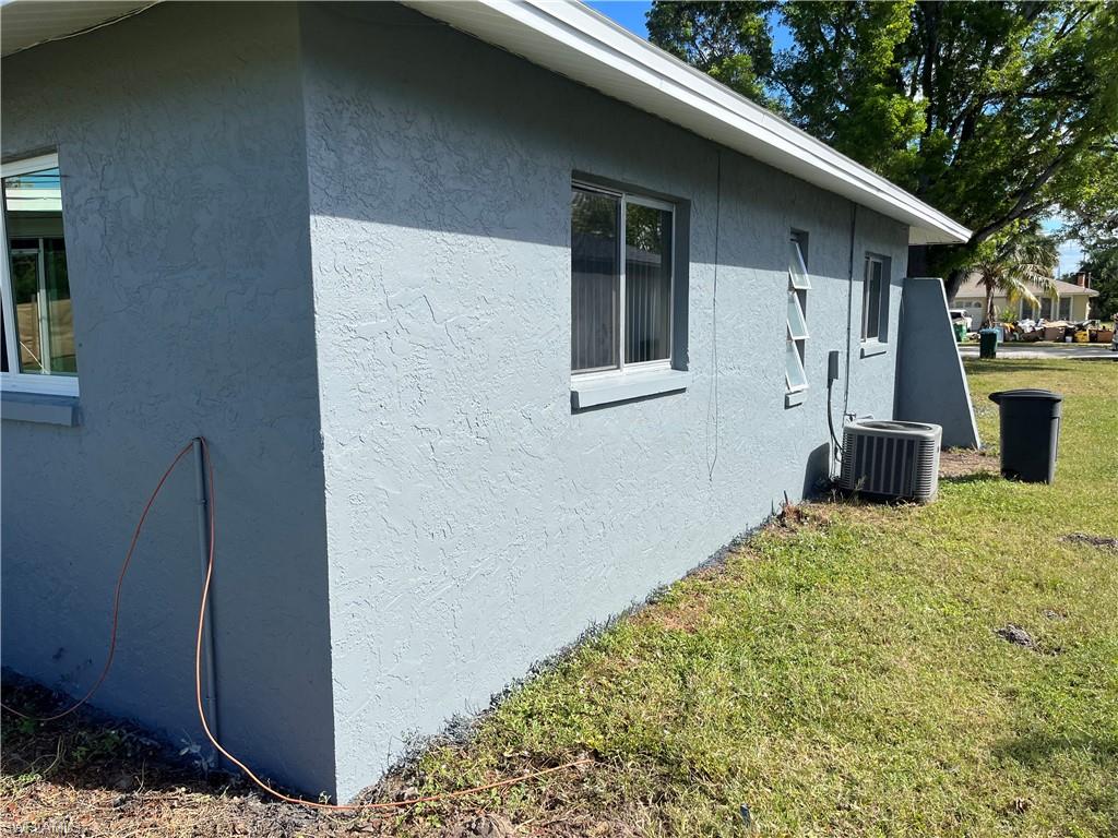 View of home's exterior featuring central AC unit and a lawn