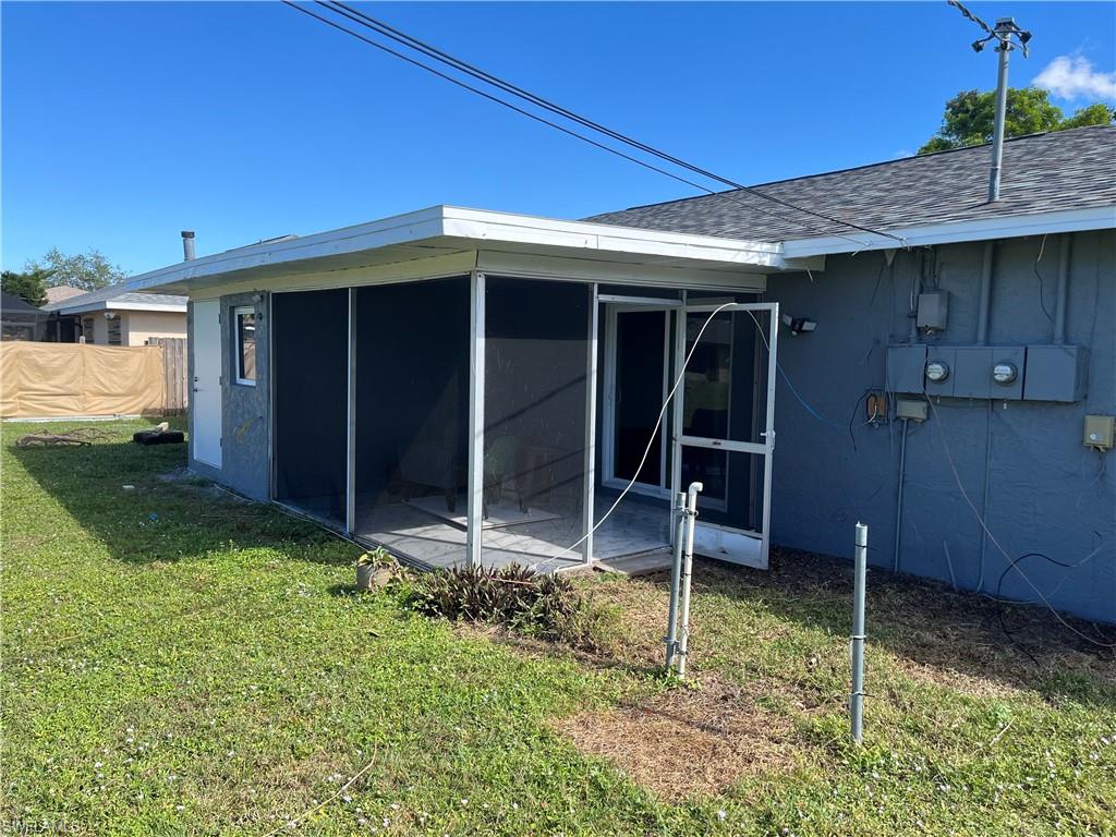 Back of property featuring a sunroom and a yard
