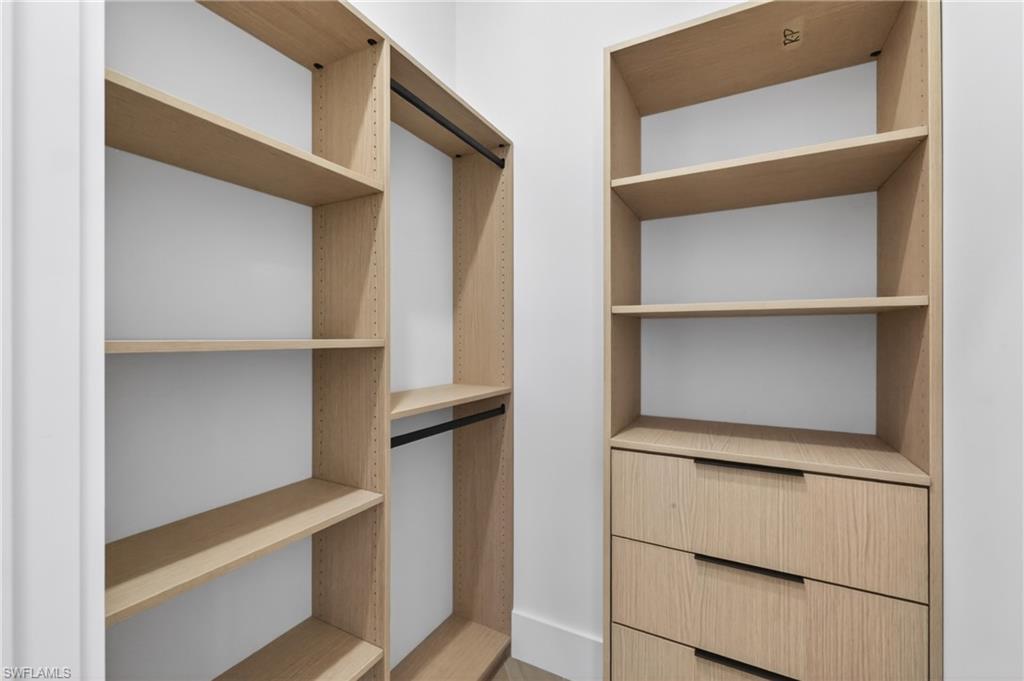 Custom closet system featuring light wood-finish shelving and integrated drawer storage