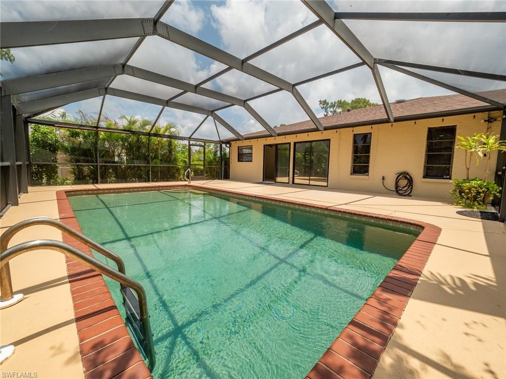 Screened-in swimming pool with a rectangular shape and brick coping