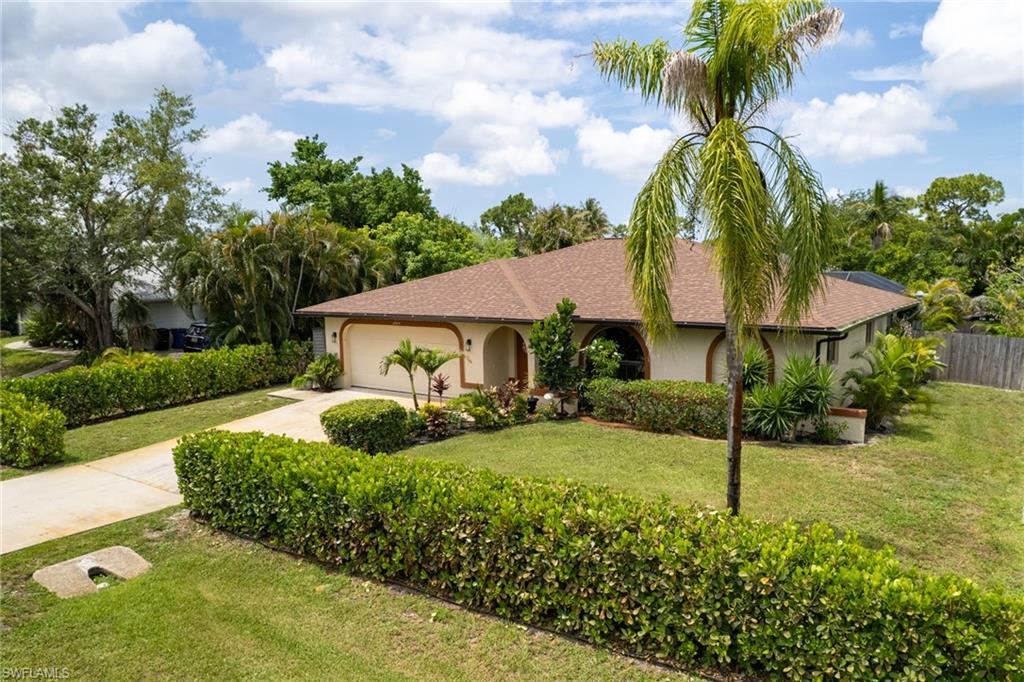 Single-story residence featuring a two-car garage, arched entryways, and a tile roof
