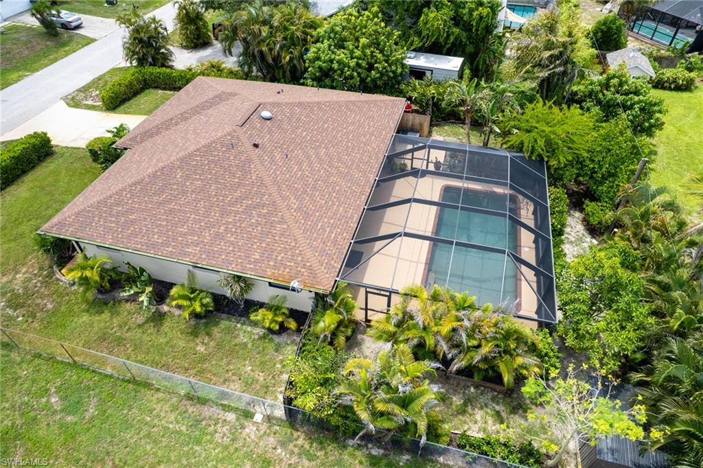 Enclosed pool area featuring a rectangular pool with a screened enclosure