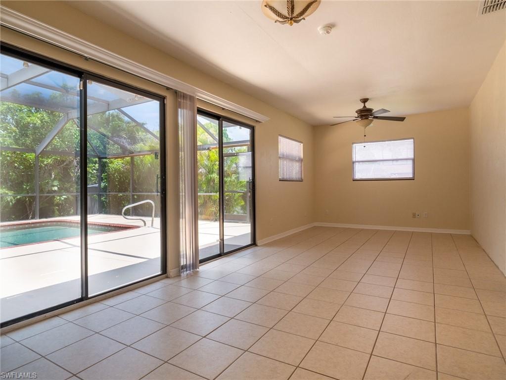 Spacious interior featuring tile flooring, multiple windows, and a ceiling fan