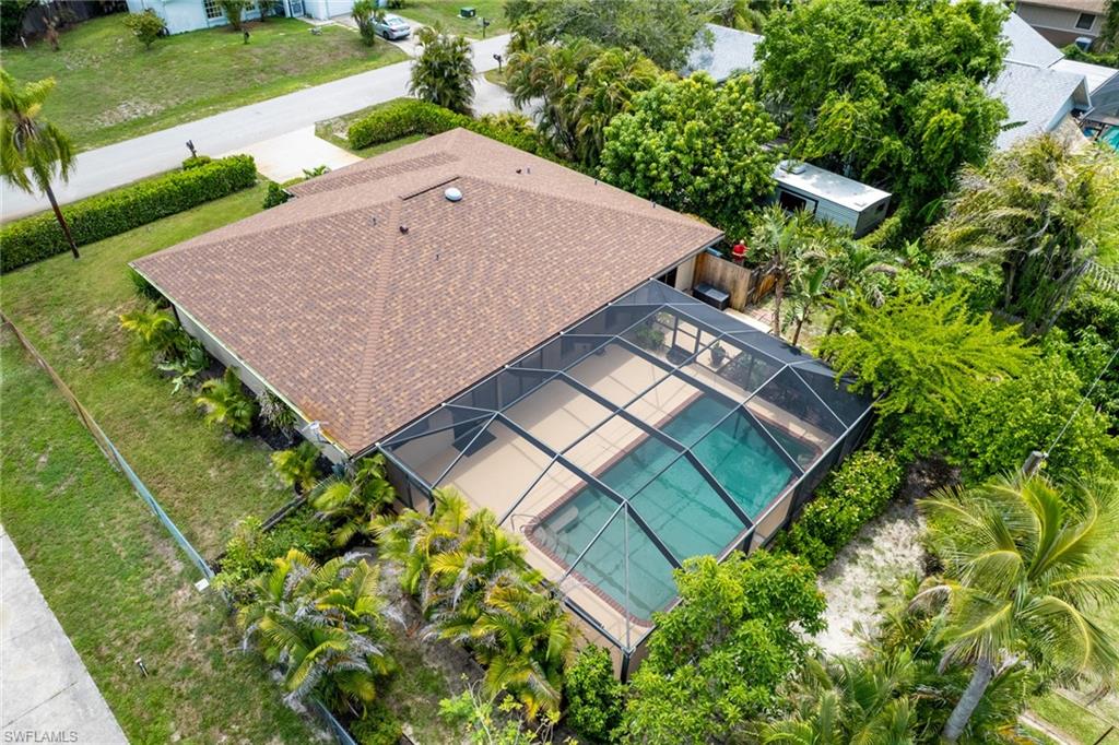Rear exterior featuring a large screened swimming pool enclosure