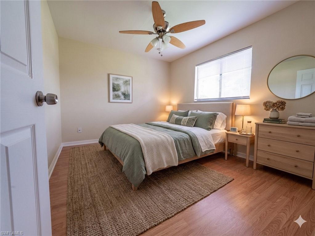 Bedroom featuring wood-finish flooring, a ceiling fan with integrated lighting, and a window with blinds