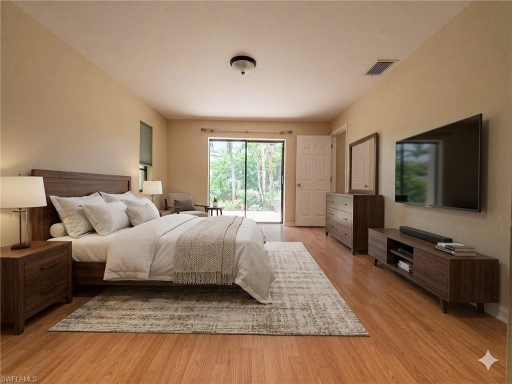 Spacious bedroom featuring wood-finish flooring, a ceiling-mounted light fixture, and beige wall paint