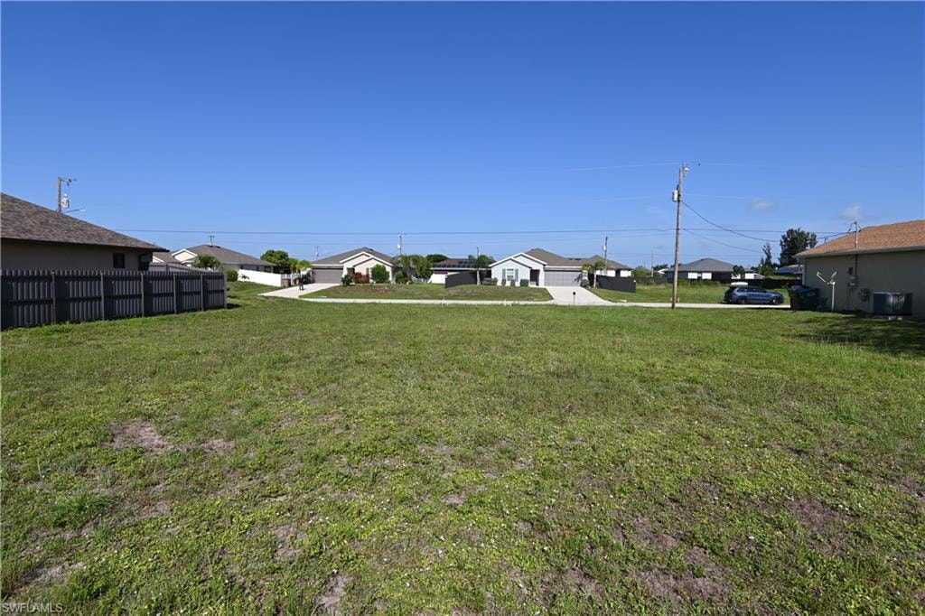 Expansive grassy lot with surrounding residential properties