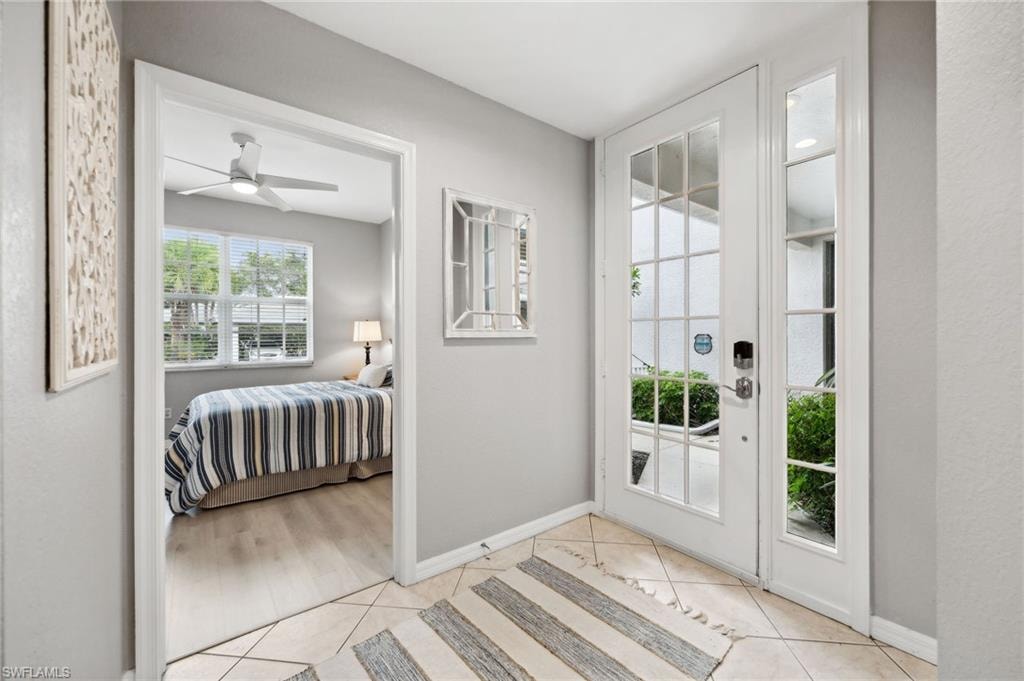 Entryway featuring light tile patterned floors and ceiling fan