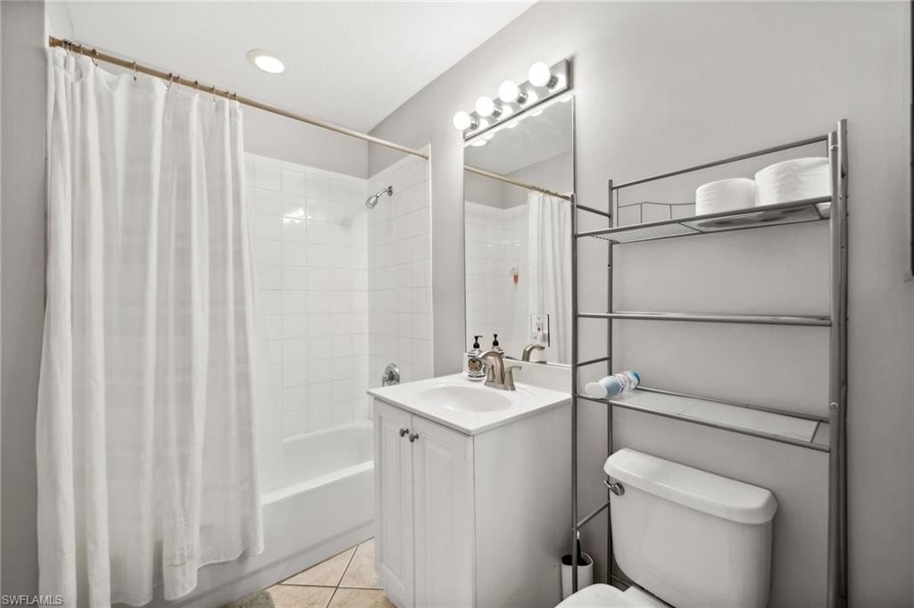 Full bathroom with vanity, toilet, tile patterned floors, and shower / tub combo