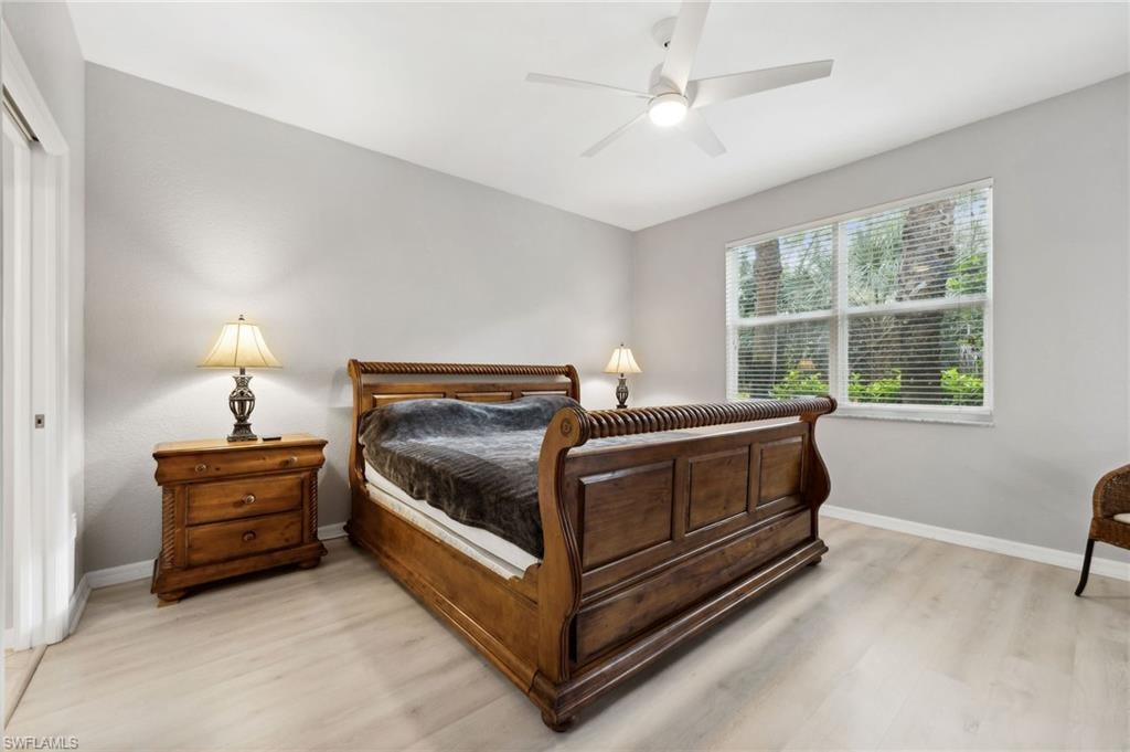 Bedroom with light wood-type flooring, ceiling fan, and a closet