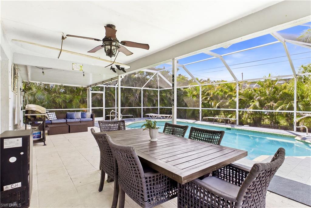 Screened lanai featuring a covered patio, ceiling fan with integrated lighting, and an in-ground swimming pool