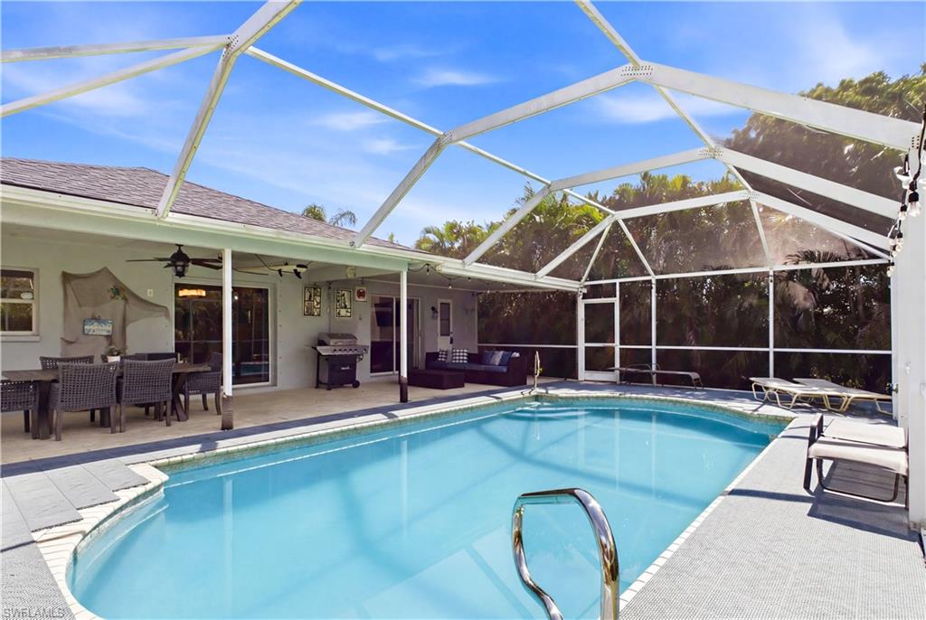 Screened-in pool area featuring a blue-tiled swimming pool and surrounding deck