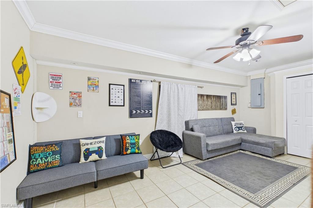 Flex room featuring neutral wall tones, crown molding, a ceiling fan with integrated lighting, tiled flooring, and a white bi-fold door