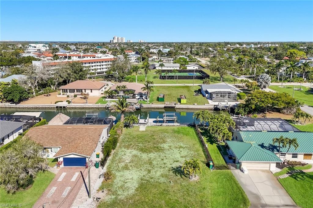 Canal-front lot featuring ample space for development, established landscaping, and a clear expanse of land - Virtually Edited Image